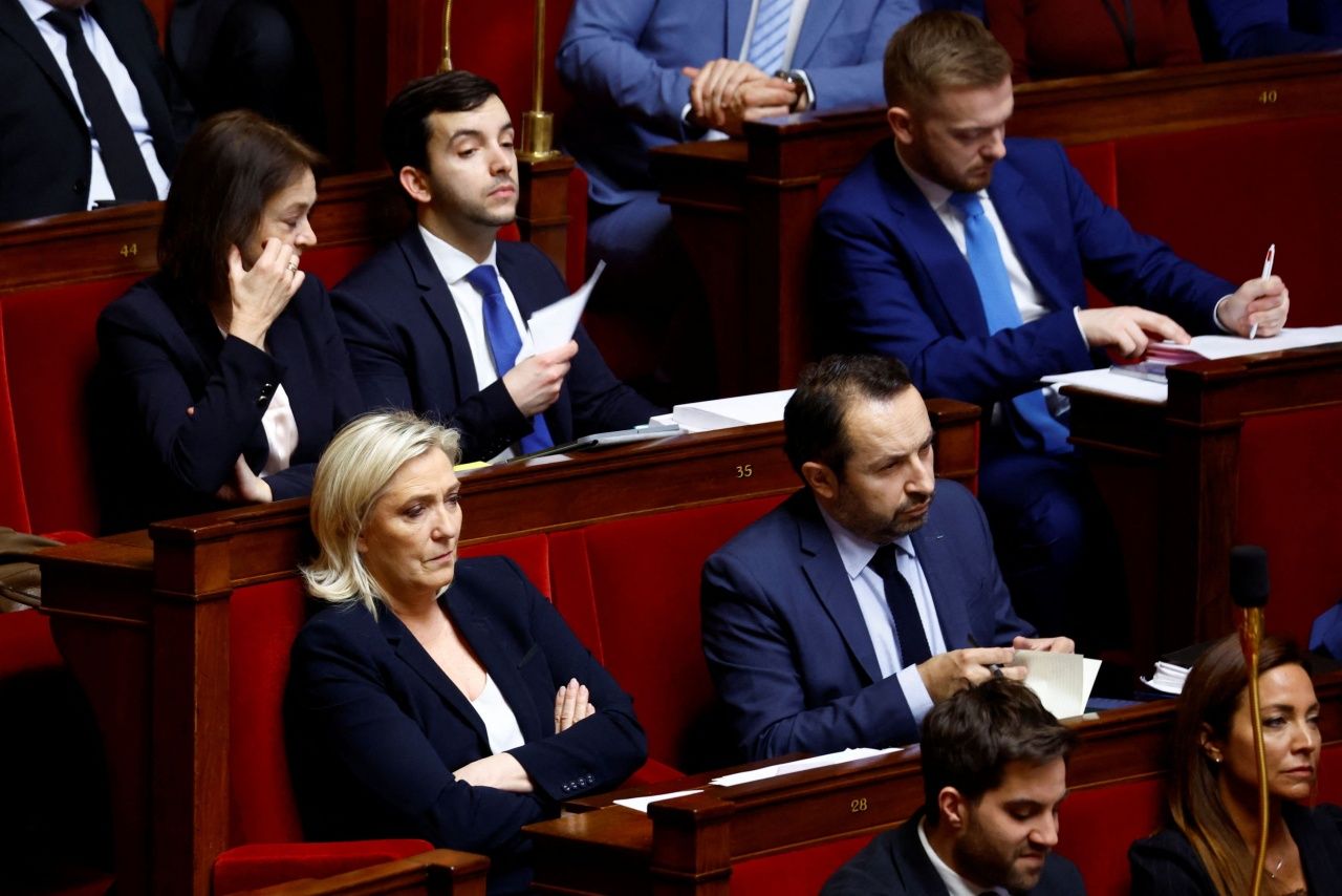 มารีน เลอเปน นั่งกอดอกอย่างเคร่งเครียด หลังรัฐบาลประธานาธิบดีเอ็มมานูเอล มาครง อาศัยอำนาจตามมาตรา 49.3 ในรัฐธรรมนูญ ชิงผ่านกฎหมายปฏิรูประบบบำนาญ โดยไม่ต้องผ่านการลงมติเห็นชอบจากสภาผู้แทนราษฎร เมื่อกลางเดือนมีนาคม 2566