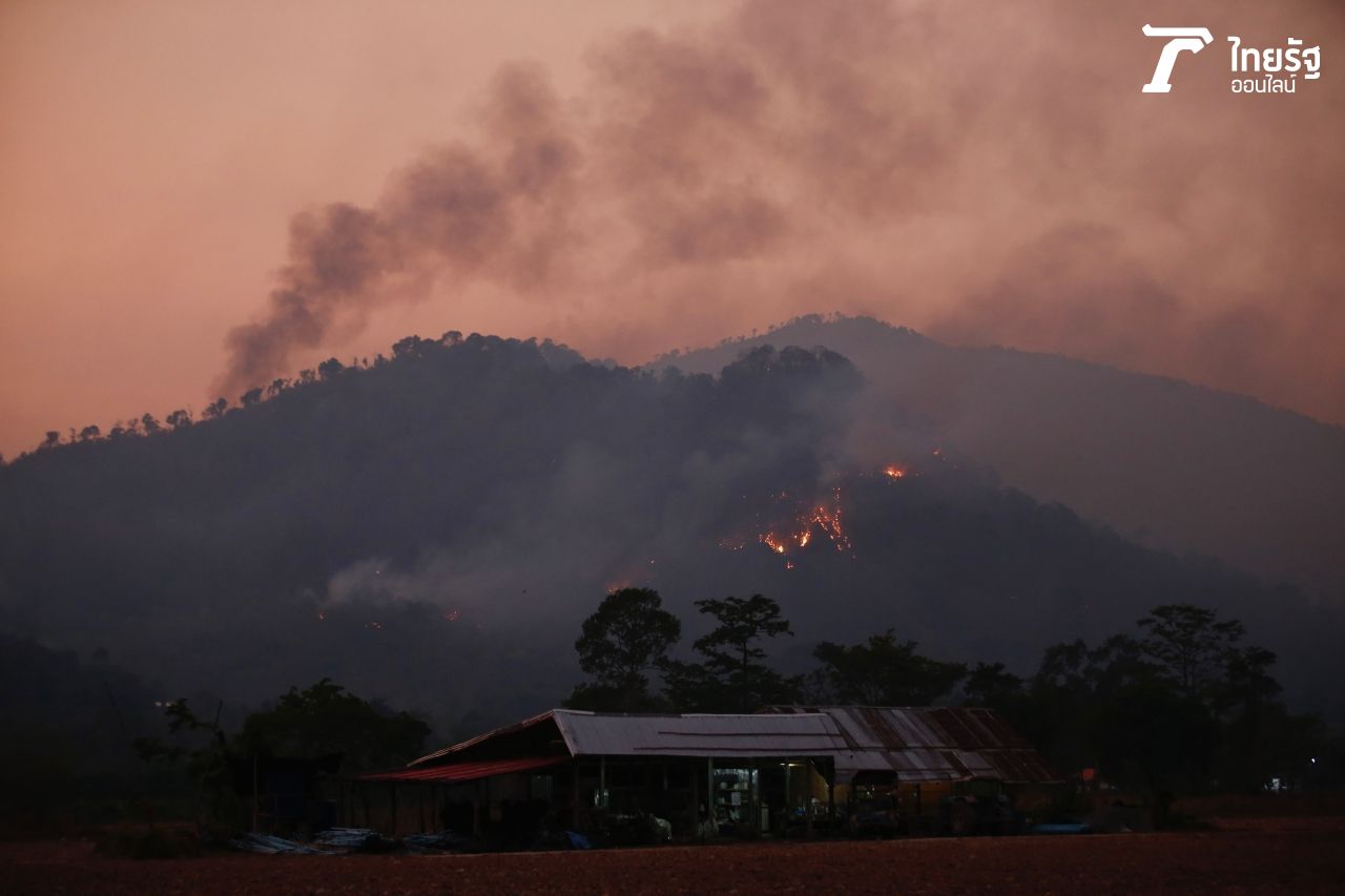 ภาพถ่ายเมื่อเวลา 18.30 น. วันที่ 30 มี.ค. 2566 ยังมีกลุ่มควันและเพลิงไหม้หลายจุดบนเนินเขาแหลม แนวเชื่อมต่อเขาตะแบก พื้นที่บ้านเขาพระ ต.เขาพระ จ.นครนายก