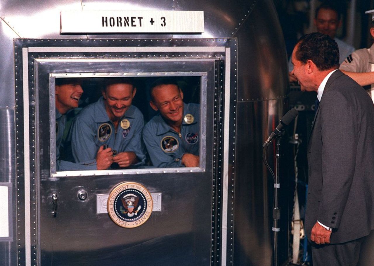 อดีตประธานาธิบดีริชาร์ด นิกสัน เดินทางมาต้อนรับทีมนักบินอวกาศ Apollo 11 ในพื้นที่กักตัว หลังเดินทางกลับสู่โลกอย่างปลอดภัย ในวันที่ 24 กรกฎาคม พ.ศ.2512 (ที่มาของภาพ : space.com)