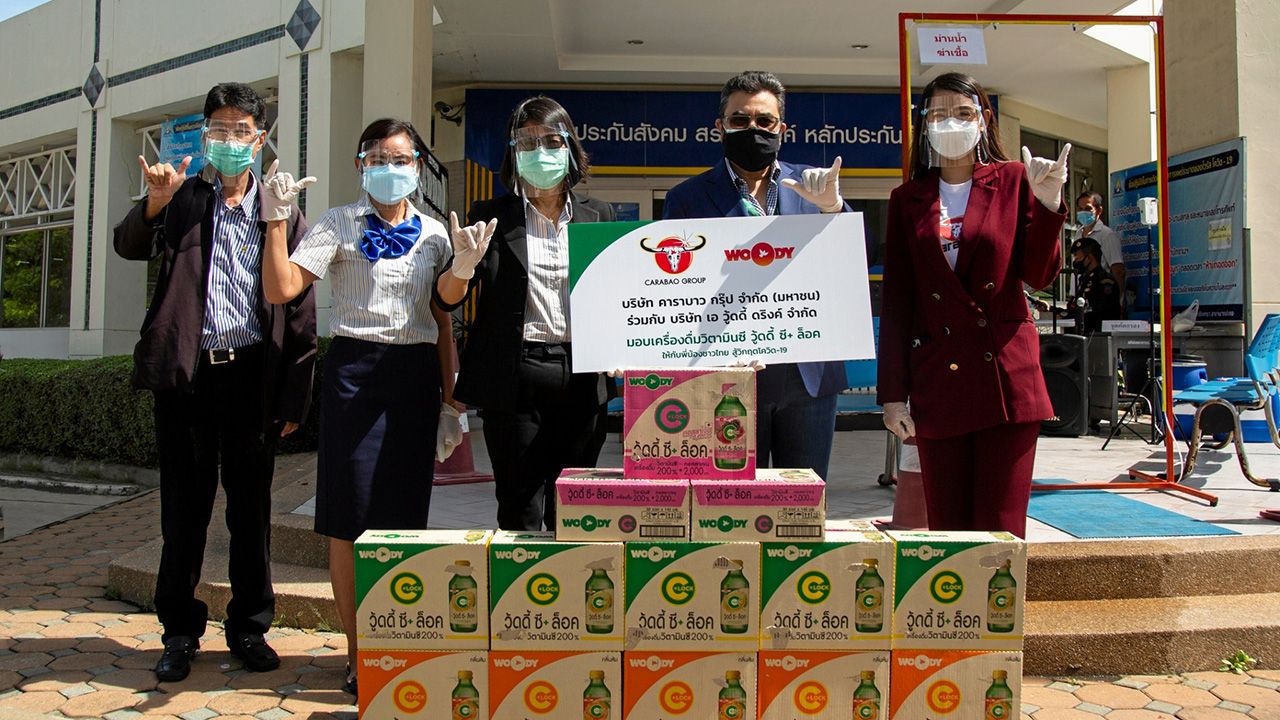 ดื่มเพลิน กมลดิษฐ สมุทรโคจร รอง กก.ผจก.คาราบาวกรุ๊ป และ กนกกร ใจชื่น มอบเครื่องดื่มวิตามินซี “วู้ดดี้ ซี+ ล็อค” กลิ่นเลมอน ส้มและมิกซ์เบอร์รี่ ให้ หัฏฐริภิม ณมงคลบุญวงษ์ เพื่อเป็นกำลังใจให้เจ้าหน้าที่ในหน่วยงานท้องถิ่น ที่สำนักงานประกันสังคม จ.ฉะเชิงเทรา วันก่อน.