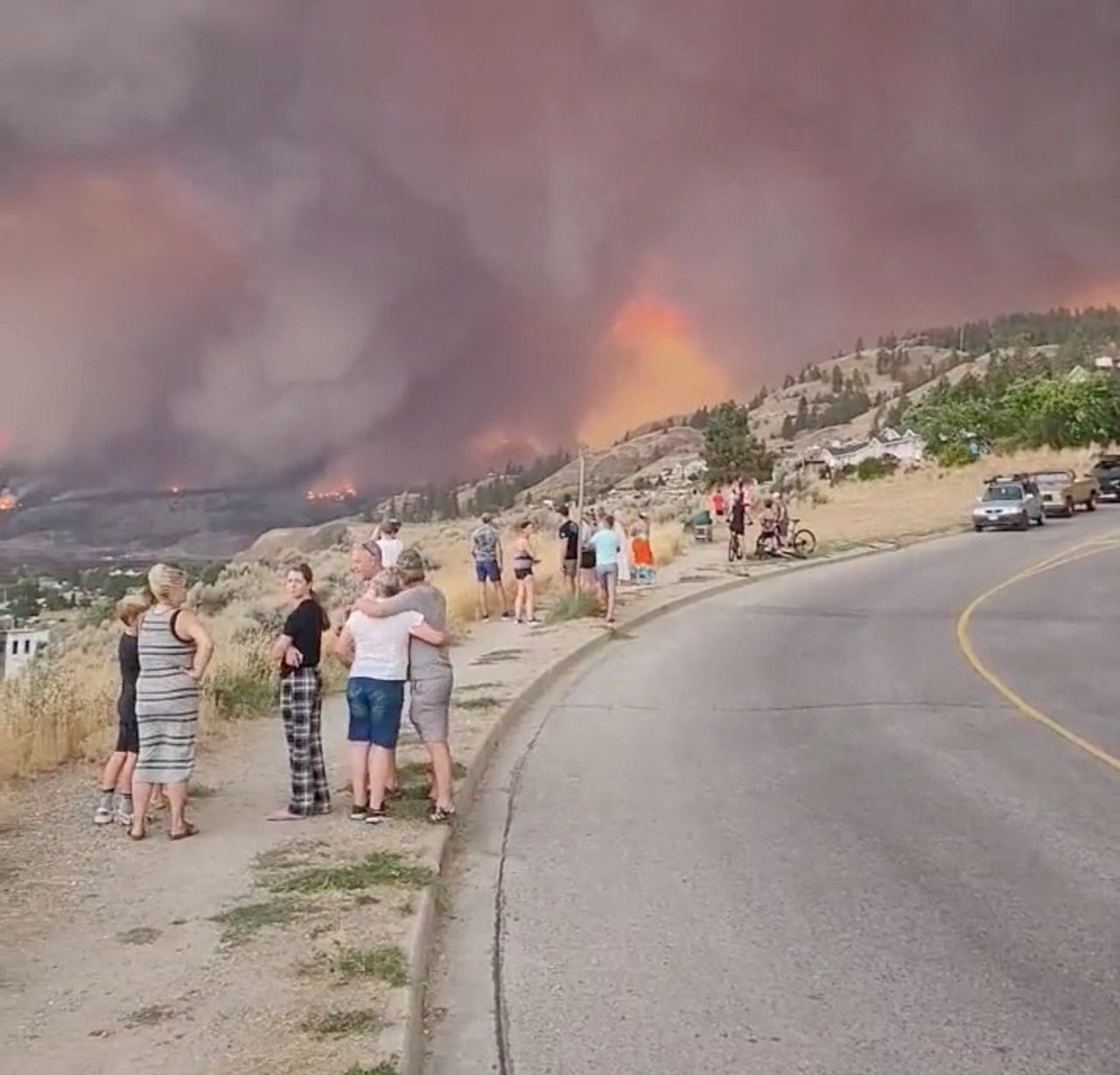 ชาวบ้านยืนมองไฟป่าที่เวสต์ คีโลว์นา