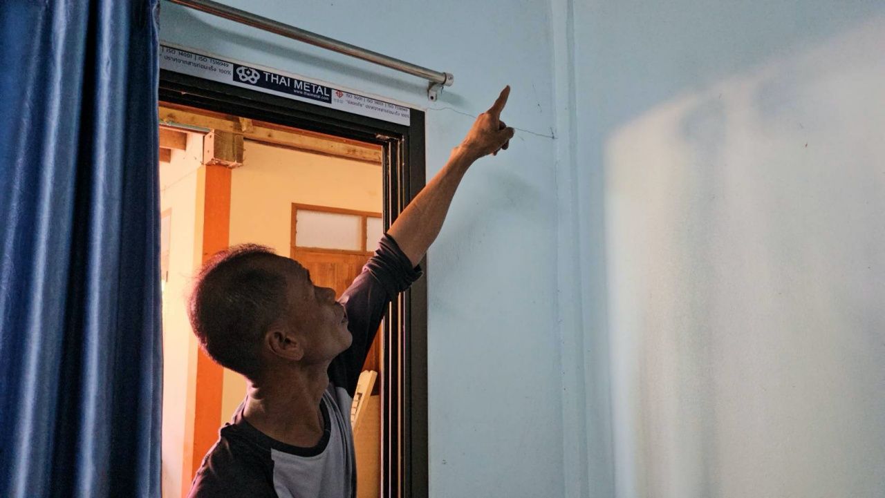 นายสมพงษ์ อ้นชาวนา กำนันตำบลนครป่าหมาก อ.บางกระทุ่ม ชี้ให้ดูรอยร้ายในบ้าน