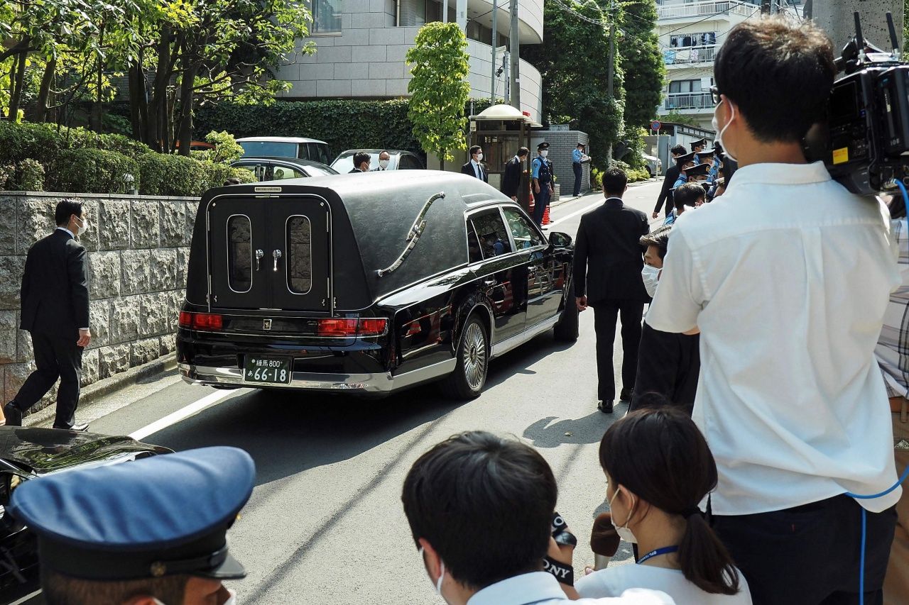 นางอากิเอะ อาเบะ นั่งอยู่ในรถยนต์ที่นำโลงศพของนายชินโสะ อาเบะ เดินทางจากบ้านพักในกรุงโตเกียว ไปยังวัดโซโจจิ เพื่อประกอบพิธีทางศาสนา 