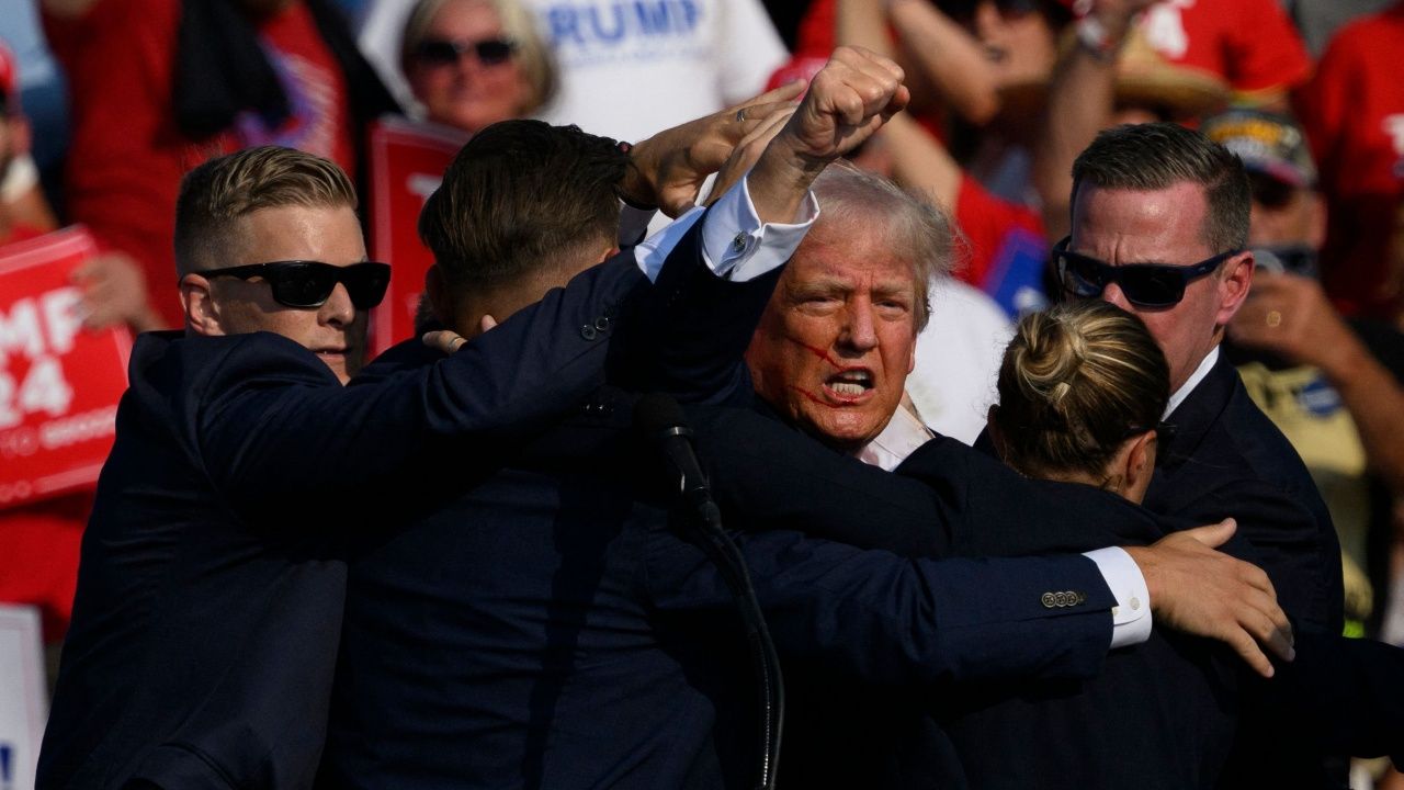 เจ้าหน้าที่คุ้มกัน โดนัลด์ ทรัมป์ ลงจากเวทีหาเสียง หลังถูกลอบยิง กระสุนเฉียดใบหูด้านขวา ขณะที่เหตุรุนแรงนี้ ทำให้คนมาฟังการปราศรัยหาเสียงของทรัมป์ เสียชีวิต 1  ราย