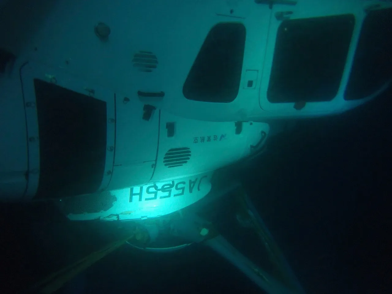 เฮลิคอปเตอร์พยาบาลจมอยู่ใต้ผิวทะเล (ภาพจาก AP / THE 7TH REGIONAL JAPAN COAST GUARD HEADQUARTERS)