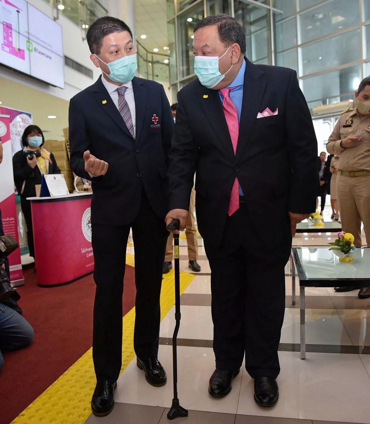 ศ.นพ.รุ่งโรจน์ สาธิตวิธี การใช้ไม้เท้าให้แก่รัฐมนตรีจุติ.