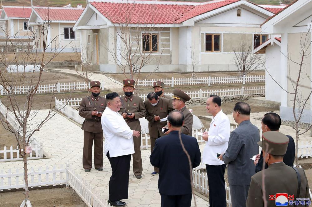 คิม จอง อึน พูดคุยกับเจ้าหน้าที่ขณะมาดูบ้านที่สร้างให้แก่ชาวบ้านประสบภัยน้ำท่วมจนบ้านพังเสียหายในเขต คิมฮวา