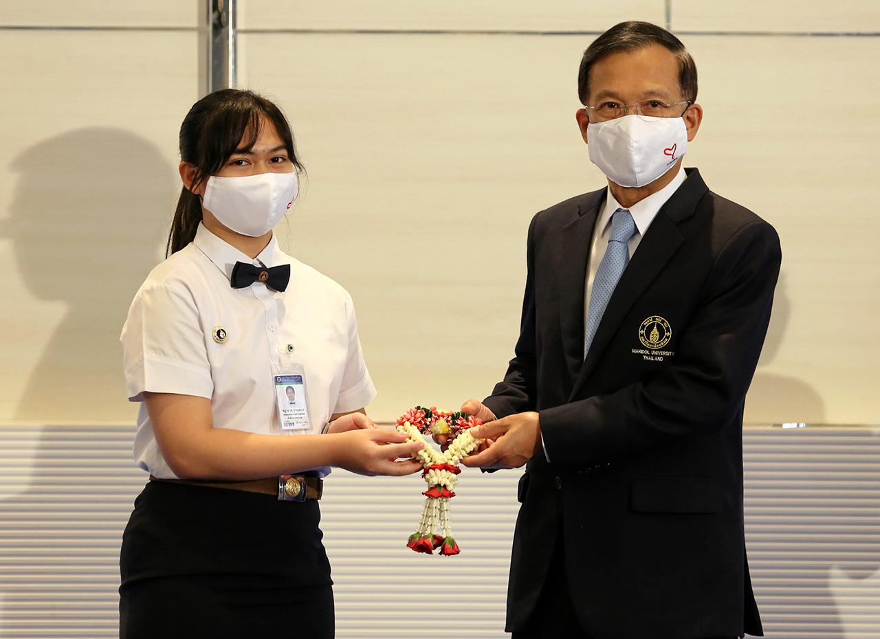 ตัวแทนนักศึกษามอบพวงมาลัยแด่คณะกรรมการมูลนิธิรามาธิบดีและคณาจารย์.