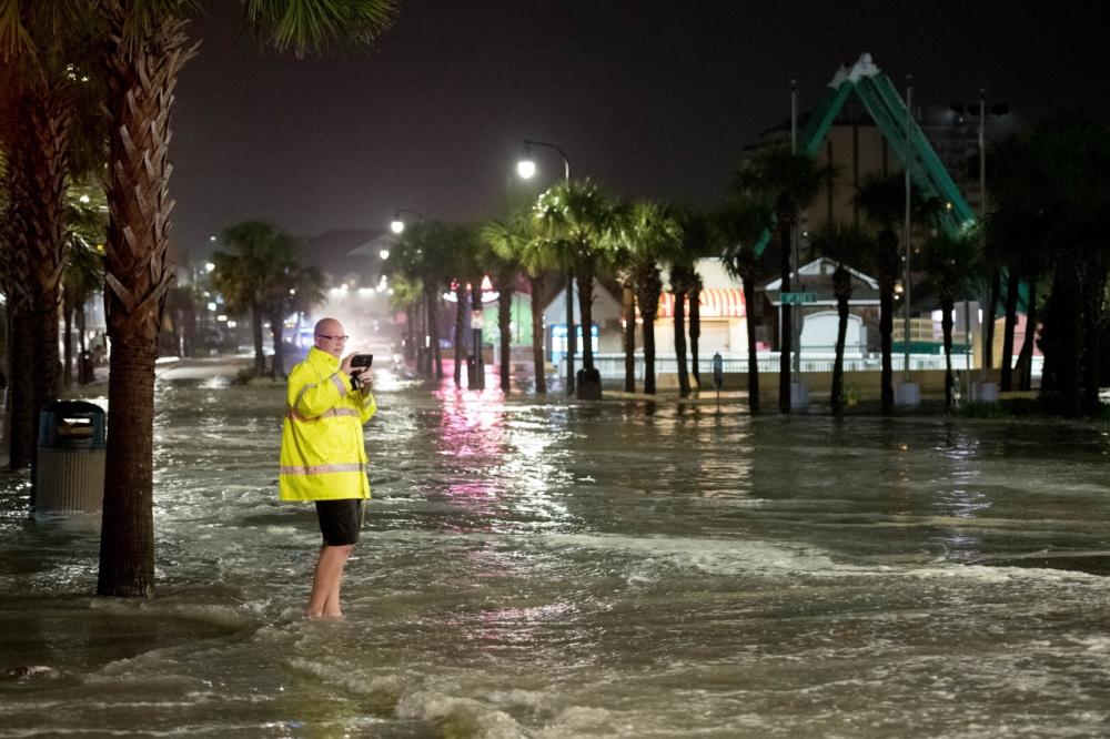 ประชาชนในเมืองMyrtle Beach รัฐเซาท์ แคโรไลนา ลุยน้ำถ่ายรูปเหตุการณ์น้ำท่วม จากอิทธิพลพายุเฮอริเคน อีเซเอียส