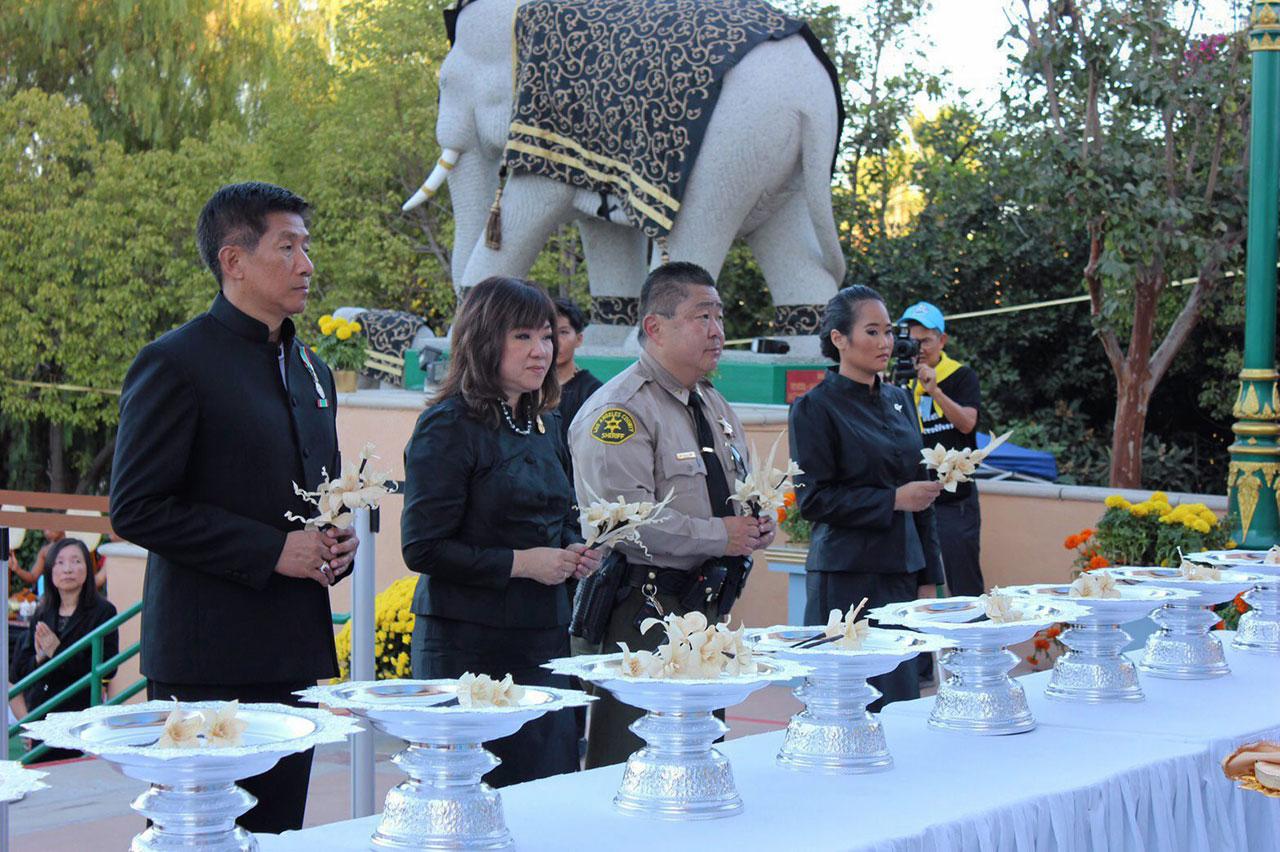 คิด ฉัตรประภาชัย ผช.นายอำเภอนครลอสแอนเจลิส สหรัฐฯ และ ปิยสาร์ วิริยะกุล ตัวแทนชาวไทยเมืองรีโน รัฐเนวาดา ไปร่วมถวายดอกไม้จันทน์ ในพระราชพิธีถวายพระเพลิงพระบรมศพ ที่วัดป่าธรรมชาติ เมืองลานพวนเต.