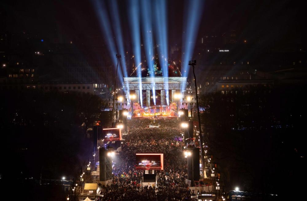 ผู้คนจำนวนมากรวมตัวกันที่หน้าเวทีการแสดง หน้าประตูบรานเดนบวร์ก ในกรุงเบอร์ลิน ของเยอรมนี