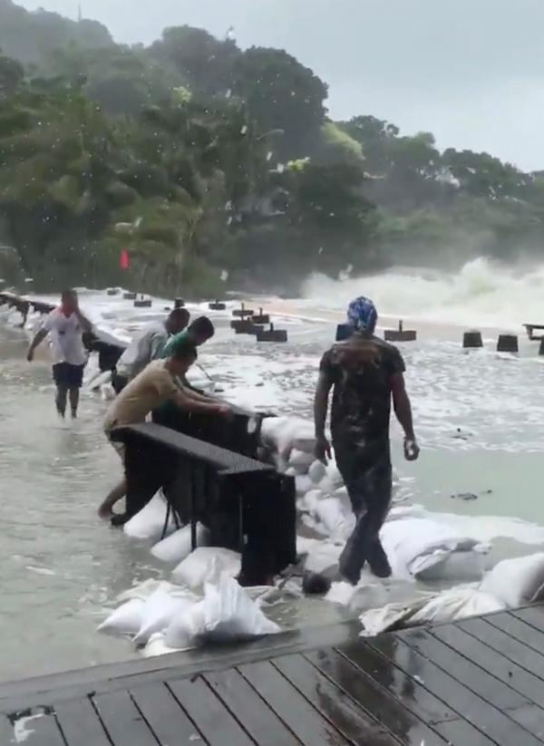 ช่วยกันวางแนวกระสอบทรายกันคลื่นสูงซัดฝั่ง ที่หาดท้องทราย บนเกาะสมุย