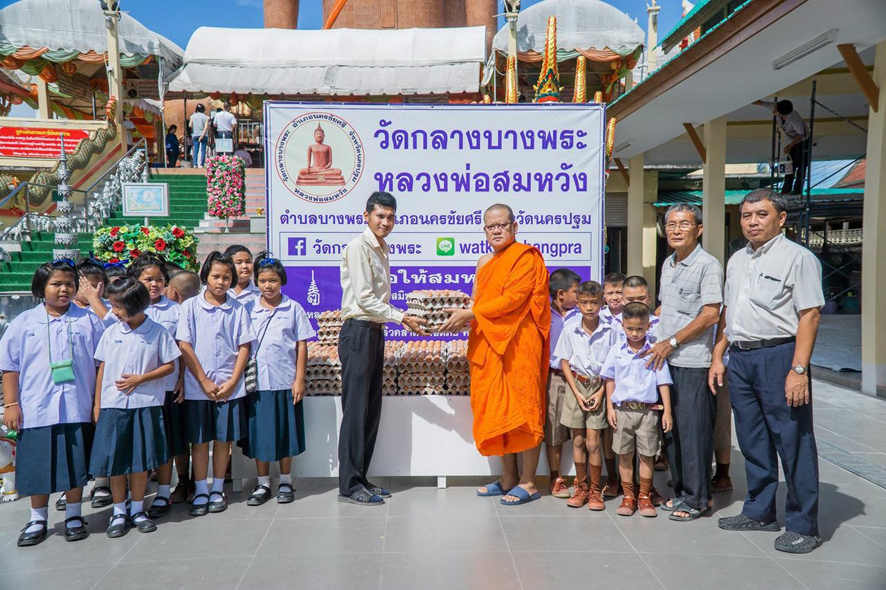 พระครูศรีสุตากร เจ้าอาวาสวัดกลางบางพระ มอบไข่ไก่ที่ญาติโยมนำไปถวายแก้บนให้กับนักเรียนโรงเรียนต่างๆเป็นอาหารกลางวัน.