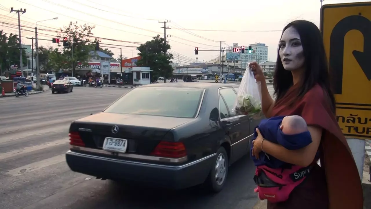 แม่ค้าสาว ไอเดียบรรเจิด แต่งชุด"แม่นาคอุ้มลูก"ขาย"หมูปิ้ง ไส้กรอก"