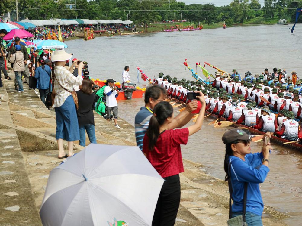 นักท่องเที่ยวพากันถ่ายภาพเรือยาวประเภทต่างๆที่เข้าร่วมการแข่งขัน โดยสองฟากลำน้ำน่านจะคลาคล่ำไปด้วยผู้คนที่เข้าร่วมชมการแข่งขัน.