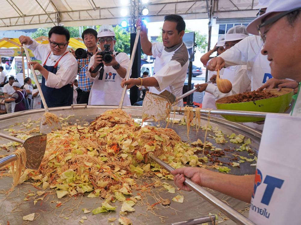 เชฟดังร่วมกันผัด “มี่สั้วกระทะยักษ์” เพื่อแจกให้ผู้ร่วมงานได้ชิมกัน.