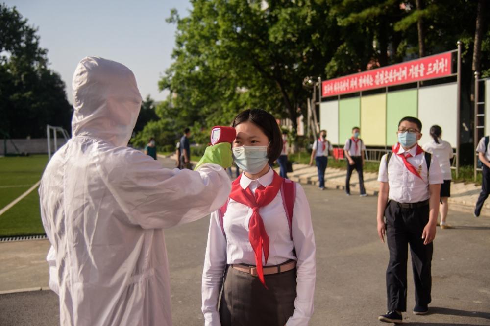 เจ้าหน้าที่ตรวจวัดอุณหภูมิของนักเรียน ก่อนเข้าพื้นที่โรงเรียนมัธยมต้นในกรุงเปียงยาง