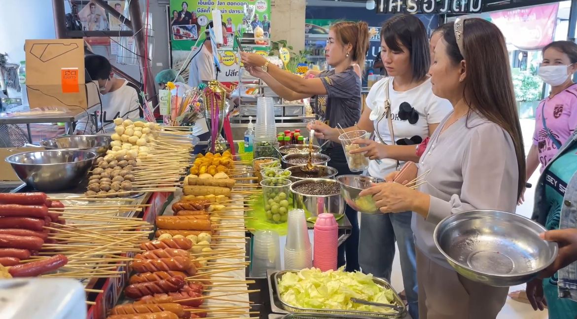 ผู้ค้าลูกชิ้นยืนกินขานรับคนละครึ่งพลัส