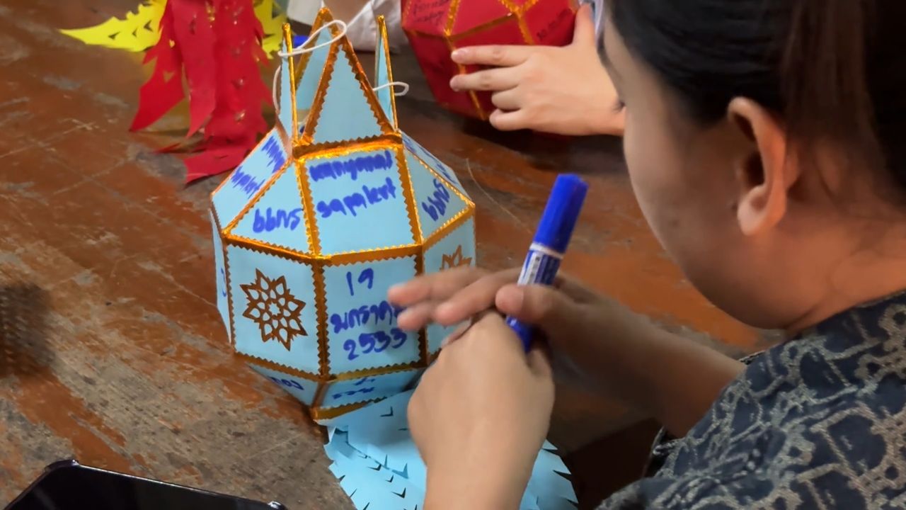 ผู้มาร่วมงานนิยมเขียนชื่อ–คำอธิษฐานลงบนโคม แล้วนำไปแขวนเพื่อความเป็นสิริมงคล