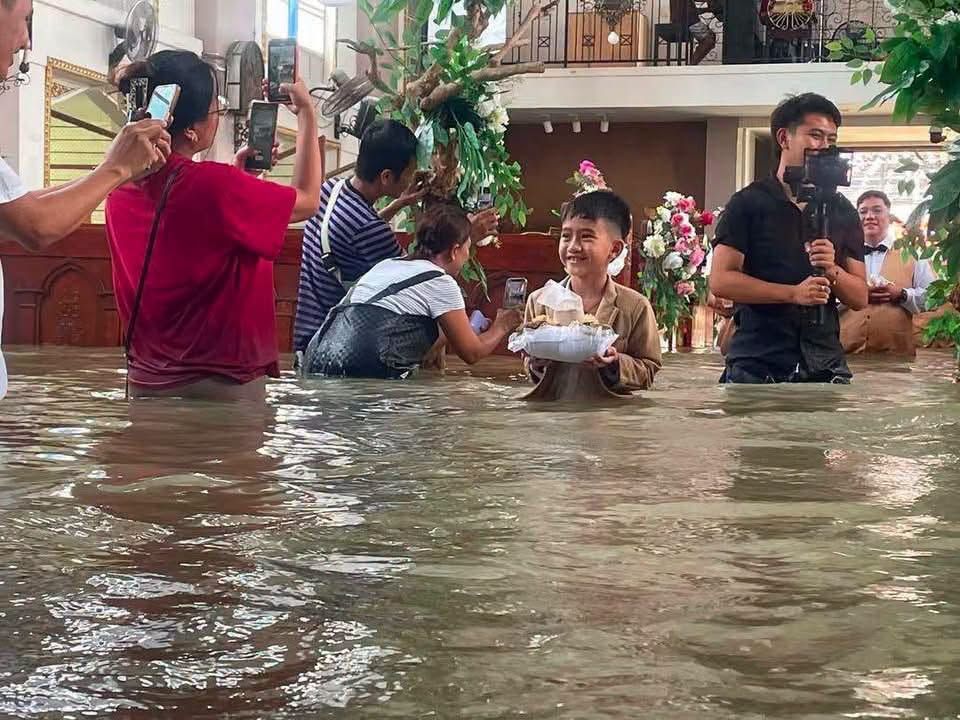 ภาพเด็กถือแหวนลุยน้ำท่วม จาก FB St. John the Baptist Parish Hagonoy 