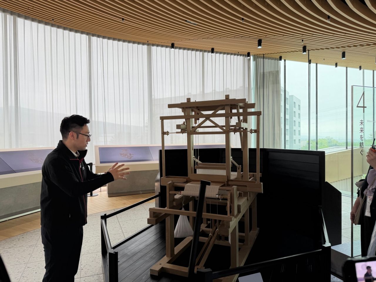 Daisuke Toyoda กำลังอธิบายเครื่องทอผ้าที่เป็นจุดกำเนิดโตโยต้า