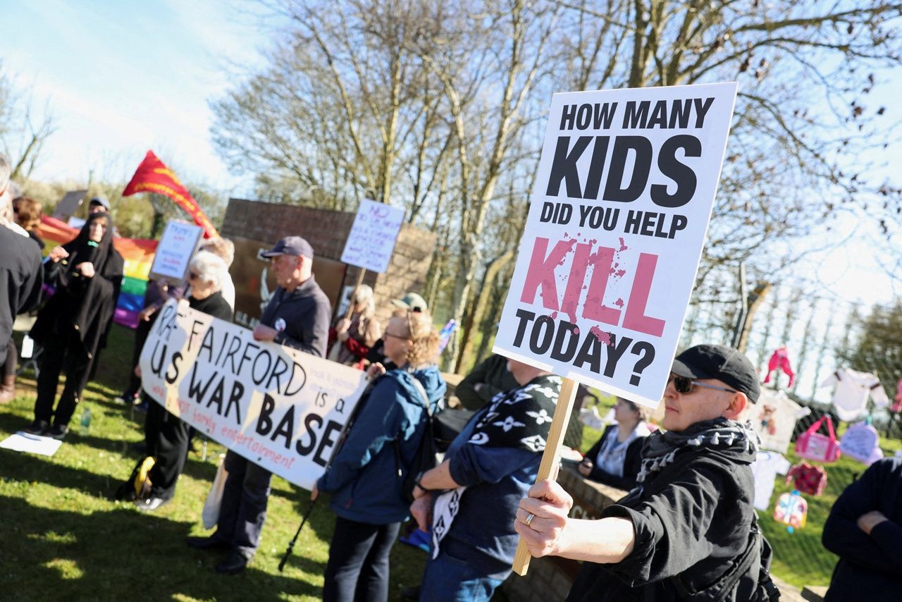 กลุ่มผู้ชุมนุมถือป้ายประท้วงที่หน้าฐานทัพอากาศ “แฟร์ฟอร์ด”ของอังกฤษ