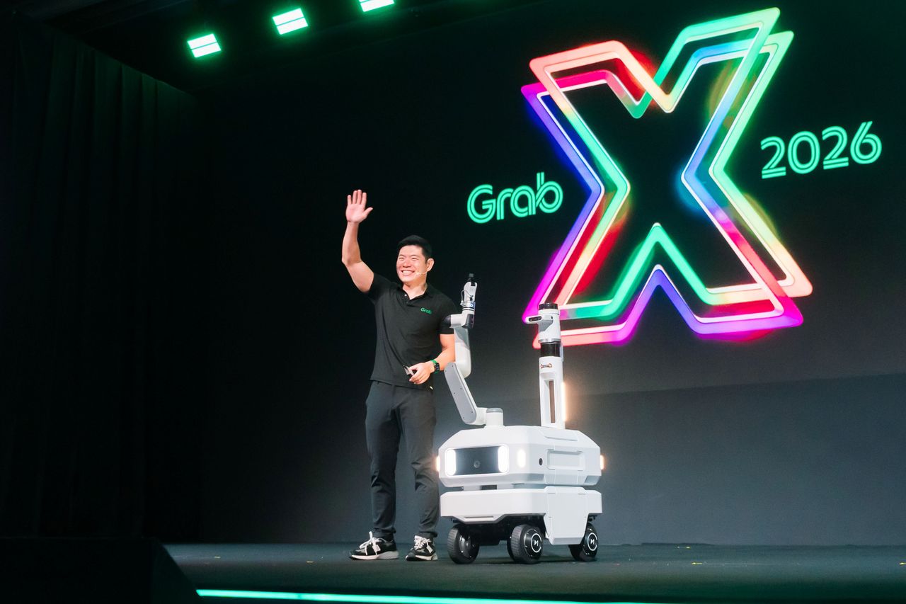 Anthony Tan ซีอีโอของ Grab บนเวที GrabX 2026 กับหุ่นยนต์ Carri