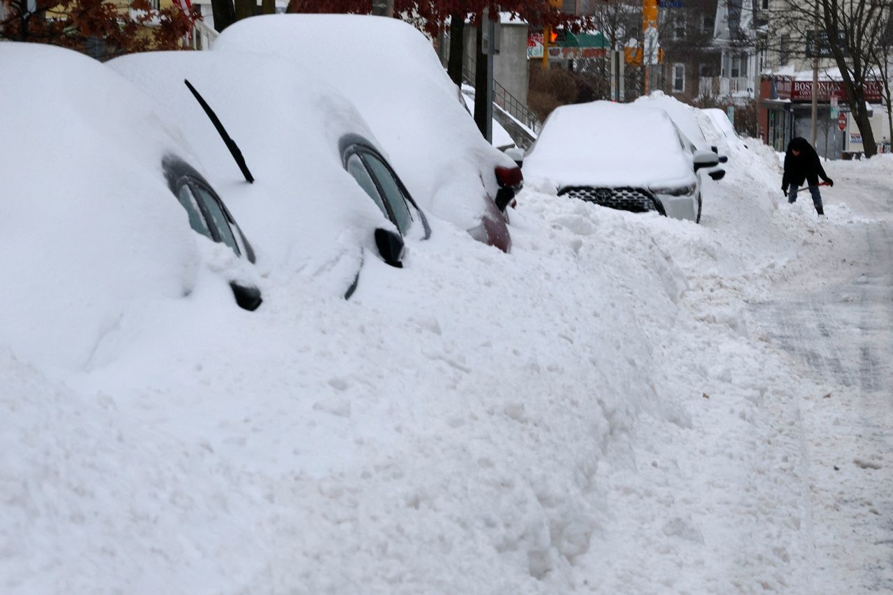 ผู้อยู่อาศัยกำลังกวาดหิมะออกจากรถของตน หลังจากเกิดพายุหิมะในเมืองซัมเมอร์วิลล์ รัฐแมสซาชูเซตส์