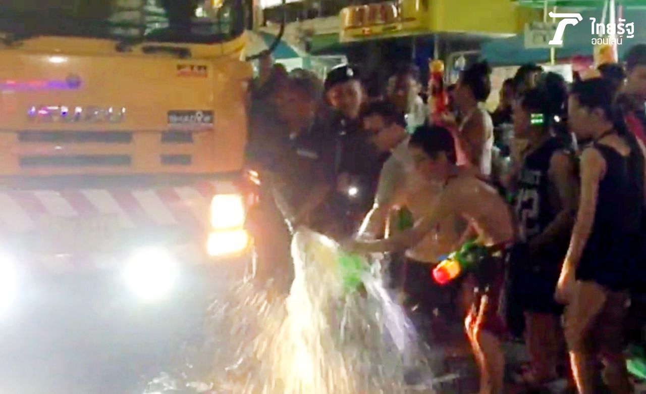 นักท่องเที่ยวเอากระบอกปืนฉีดน้ำมารองน้ำ ขณะที่เจ้าหน้าที่กำลังจะฉีดล้างทำความสะอาด