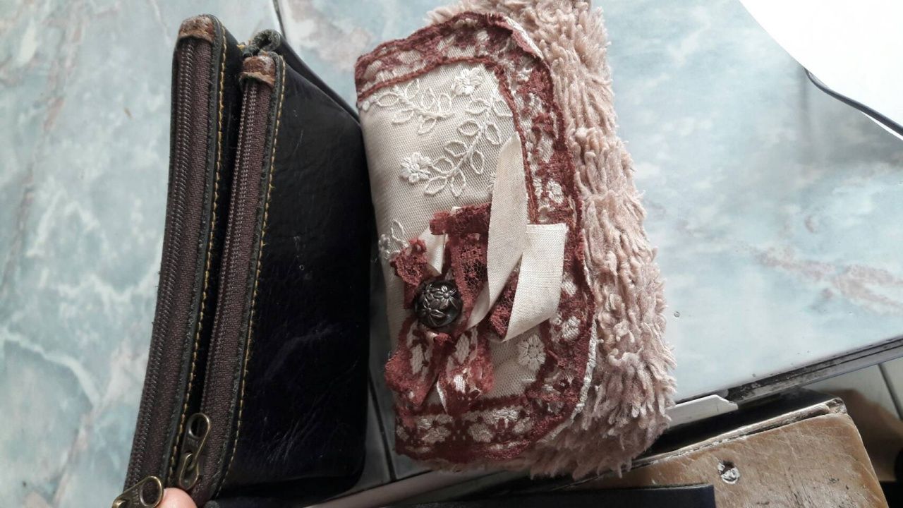 กระเป๋าสตางค์ของน้องพลอย ที่นางพัชรีนำมาใช้ ใบสีดำใส่เงิน ส่วนลายดอกไม้ไว้ใส่โทรศัพท์