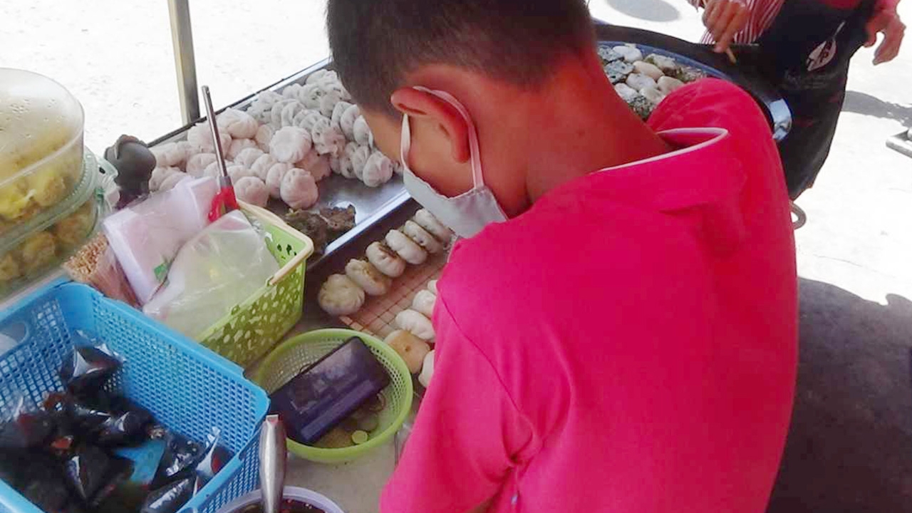 เด็กชาย ม.2 สุดขยัน เปิดมือถือเรียนออนไลน์ พร้อมช่วยยายขายกุยช่าย 