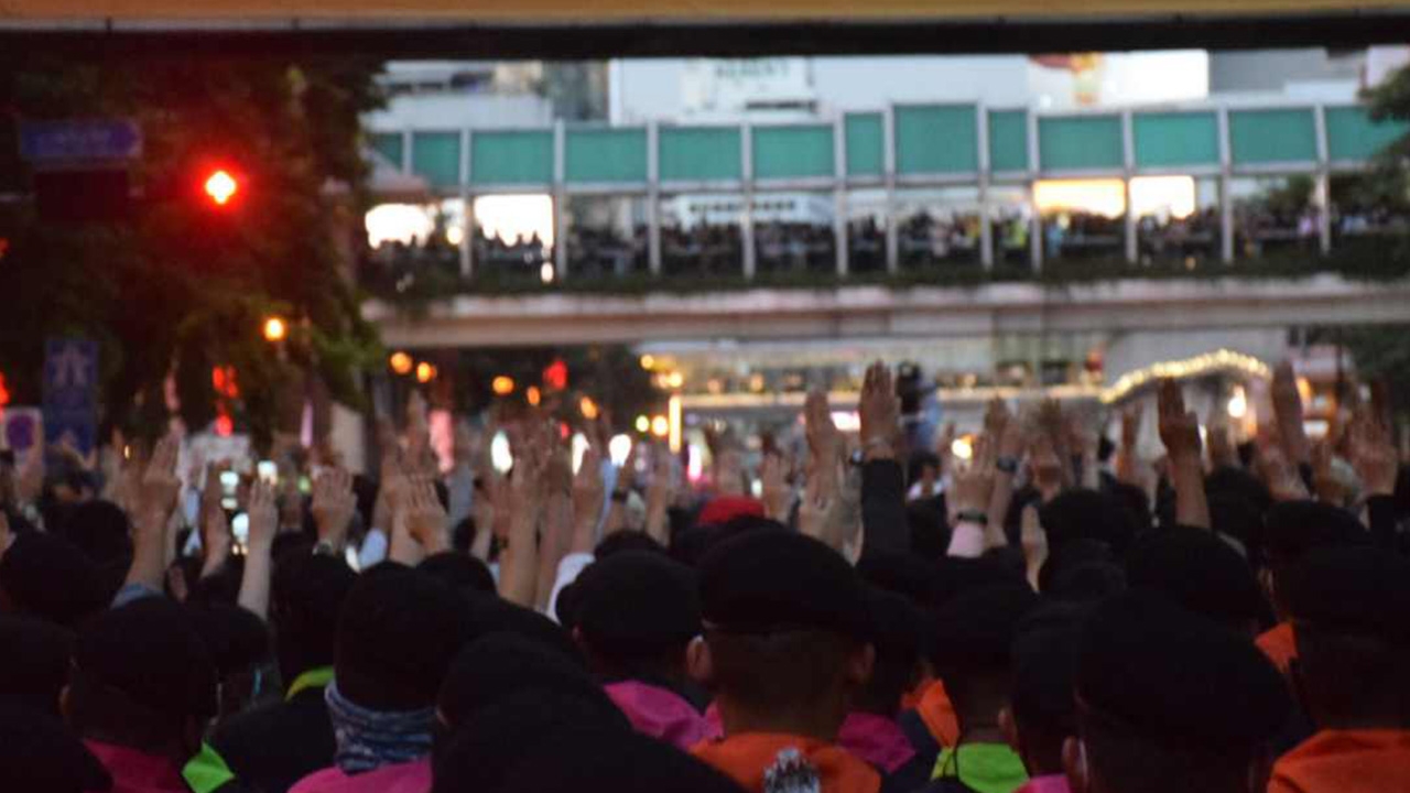 มวลชนเคารพธงชาติ ชู 3 นิ้ว แยกราชประสงค์ กลางวงล้อมกองร้อยควบคุมฝูงชน