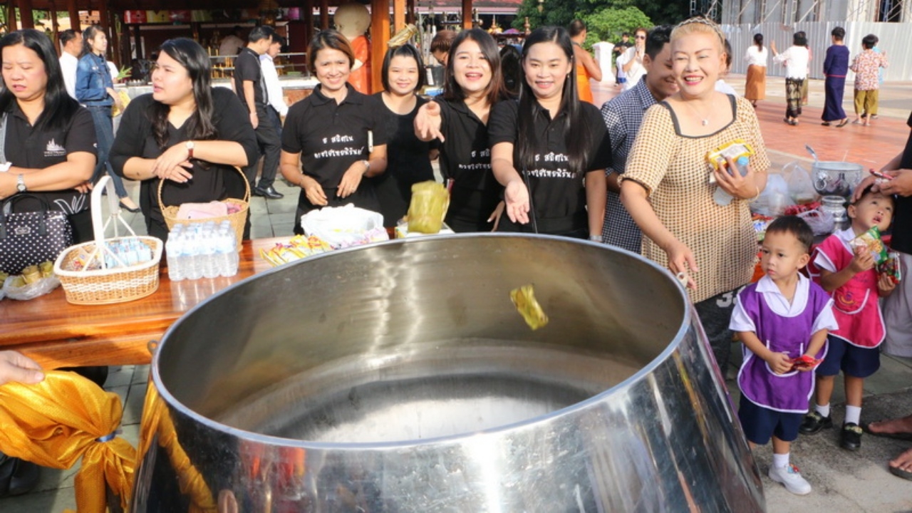 สารทไทยคึกคัก ชาวพุทธแห่ทำบุญ โยนขนม-ข้าวต้ม ลงบาตรยักษ์ 