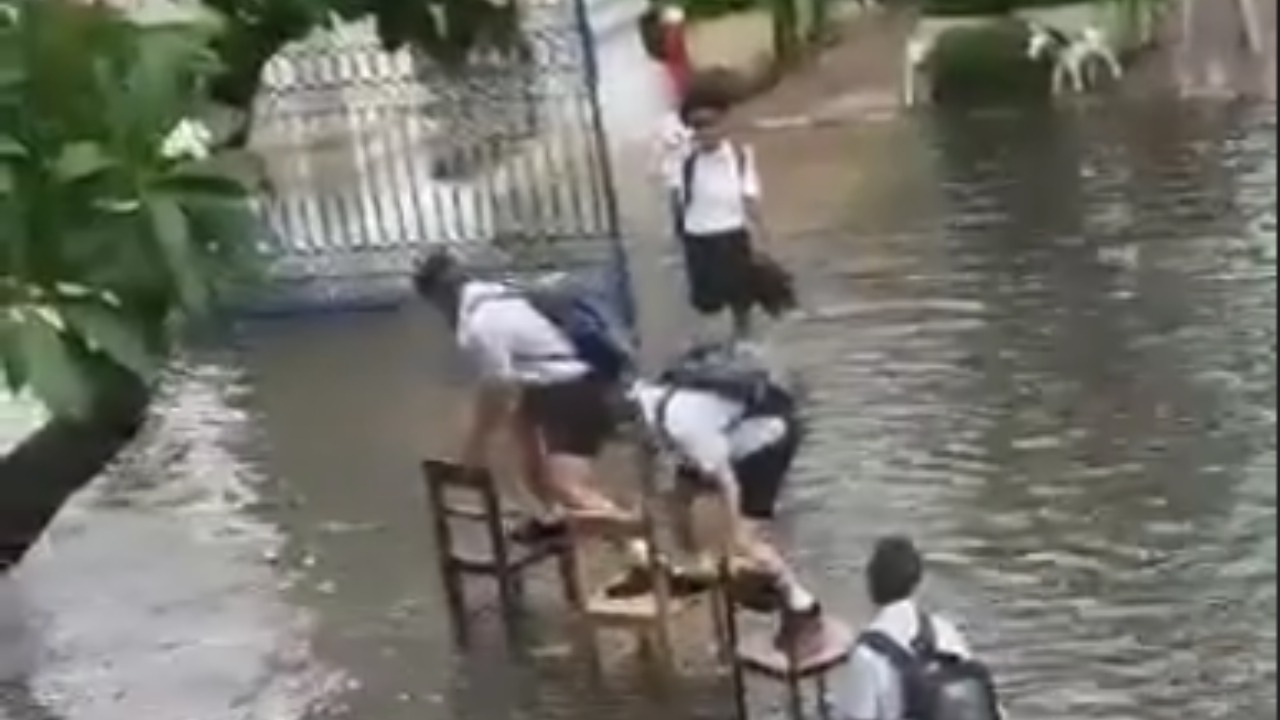 เด็กโรงเรียนดังสุดพยายาม ฝนตก น้ำท่วม กลับบ้านยังไงไม่ให้น้ำกัดเท้า (คลิป)