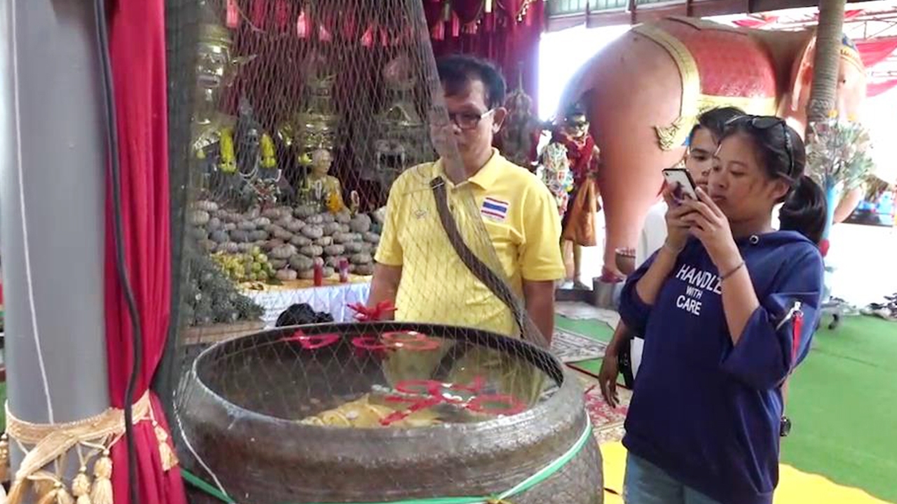 นักแสวงโชค แห่ส่องน้ำตาเทียนสีแดง "เลขเด็ด" อ่างน้ำมนต์ฤาษีเณร