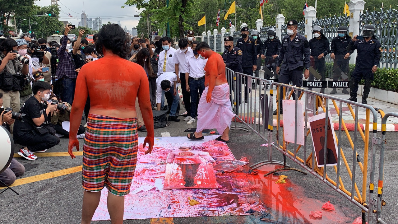 ม็อบข้างทำเนียบทาตัวแดง ป้ายสีสแตนดี้รูปนายกฯ เปิดรายชื่อ ส.ส. โหวตไว้วางใจ