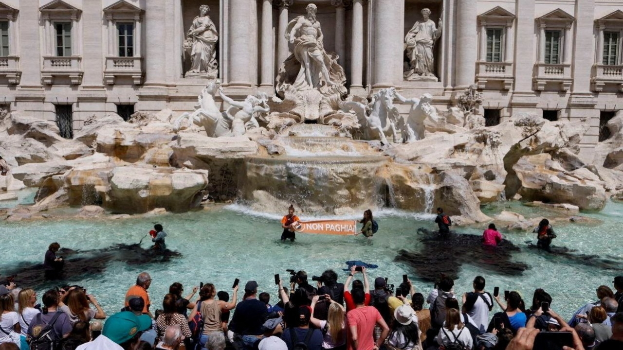 นักเคลื่อนไหวต้านโลกร้อน เทผงถ่านย้อมน้ำพุเทรวีเป็นสีดำ (คลิป)