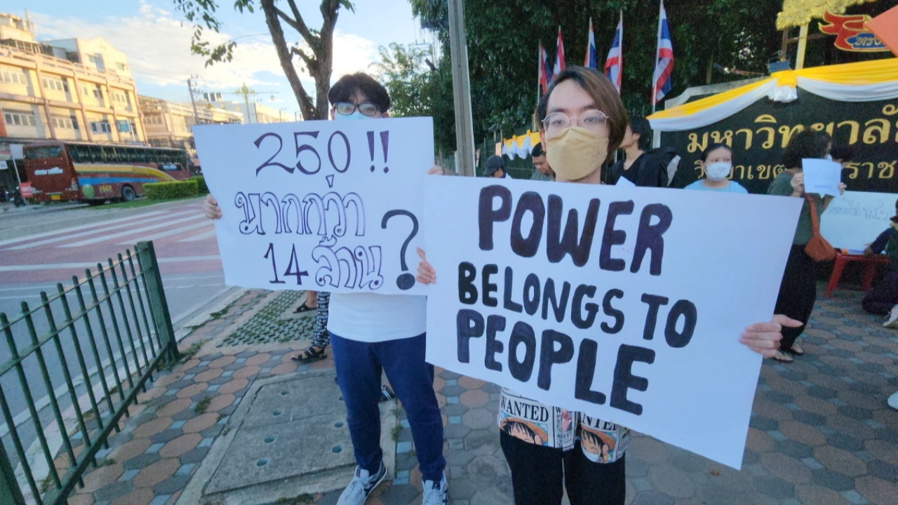 加入民主意识形态的学生在泰国艺术大学前集会，举着驱逐参议员的标语。